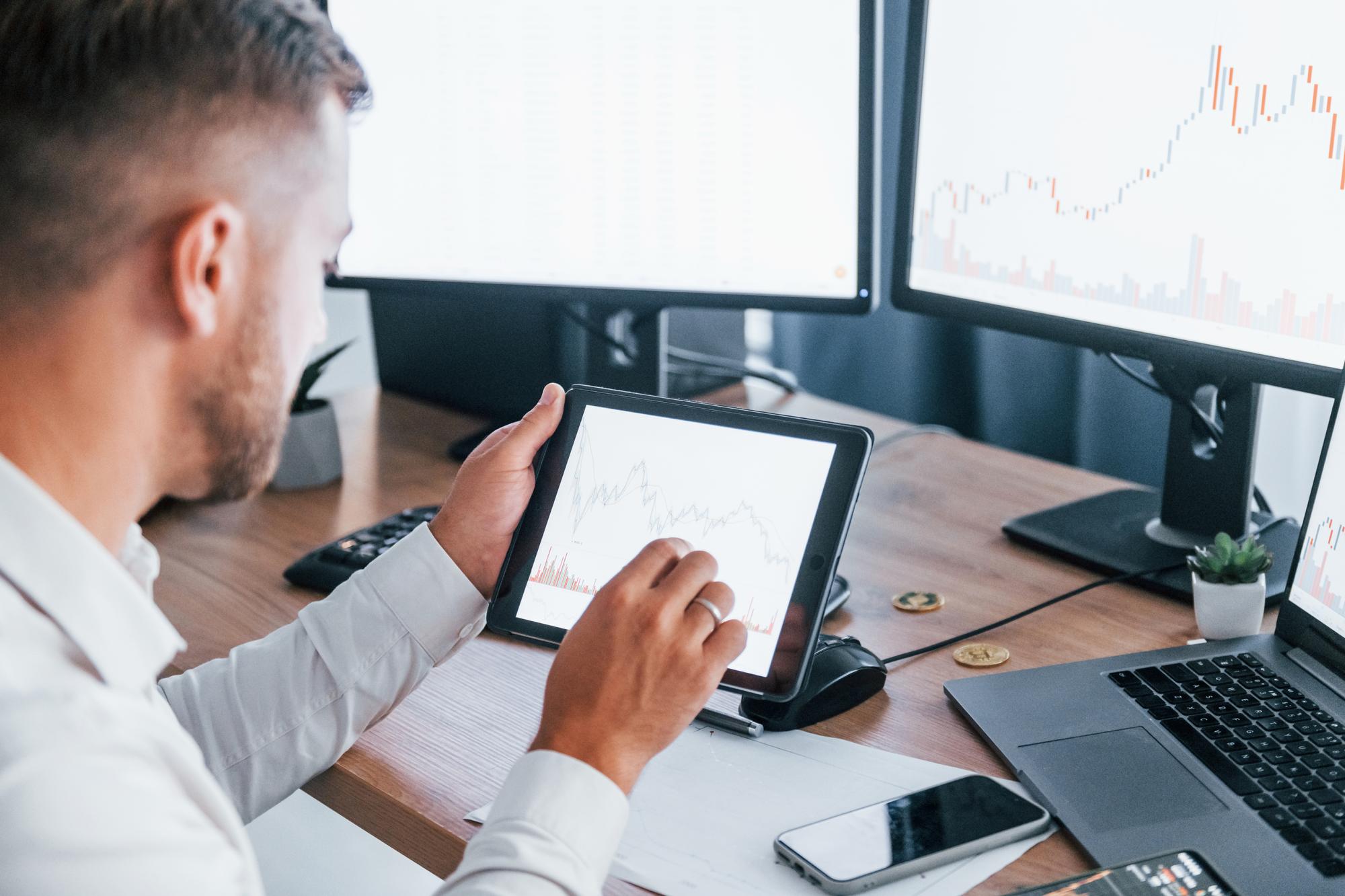 Investor analyzing stock charts on tablet